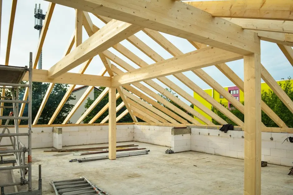 Wooden roof structure in progress with open sky view, ideal for construction themes.